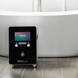 Hydrogen water bath machine on a bathroom floor in front of a white bathtub.