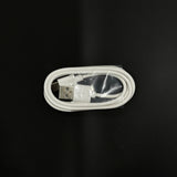 White USB charging cable coiled and wrapped in plastic on a black background