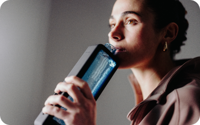 Woman drinking hydrogen water from a clear, modern bottle indoors