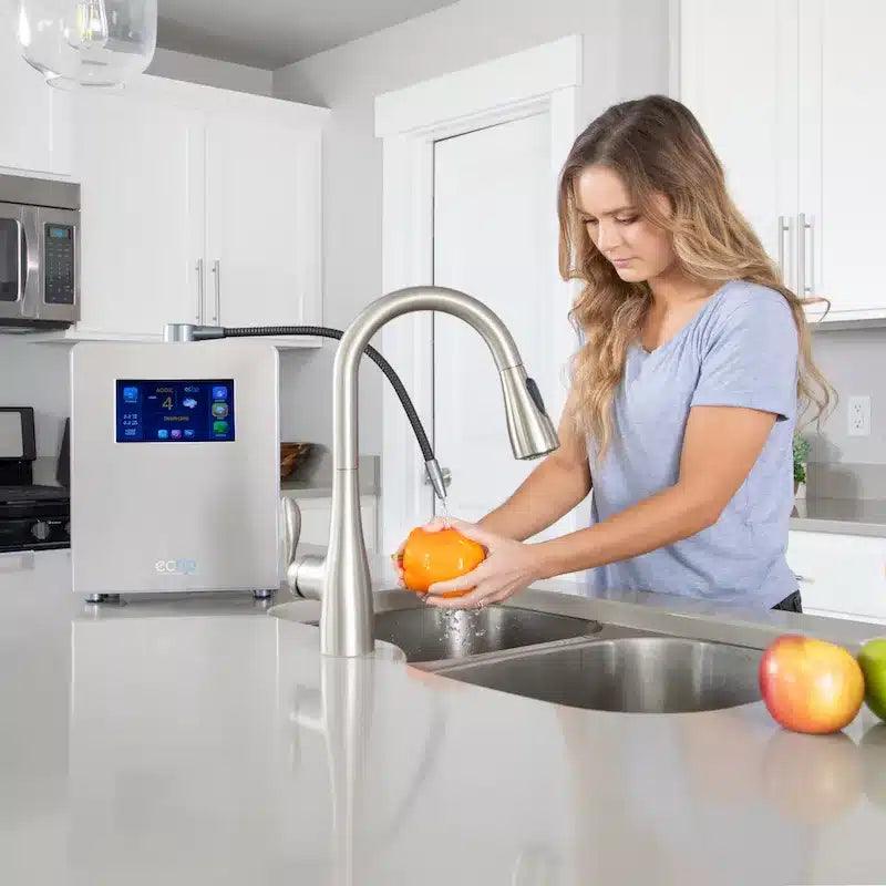 Rinsing an orange under acidic water at the sink