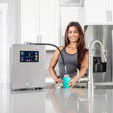 Woman filling bottle at kitchen sink with hydrogen water machine, modern countertop setup
